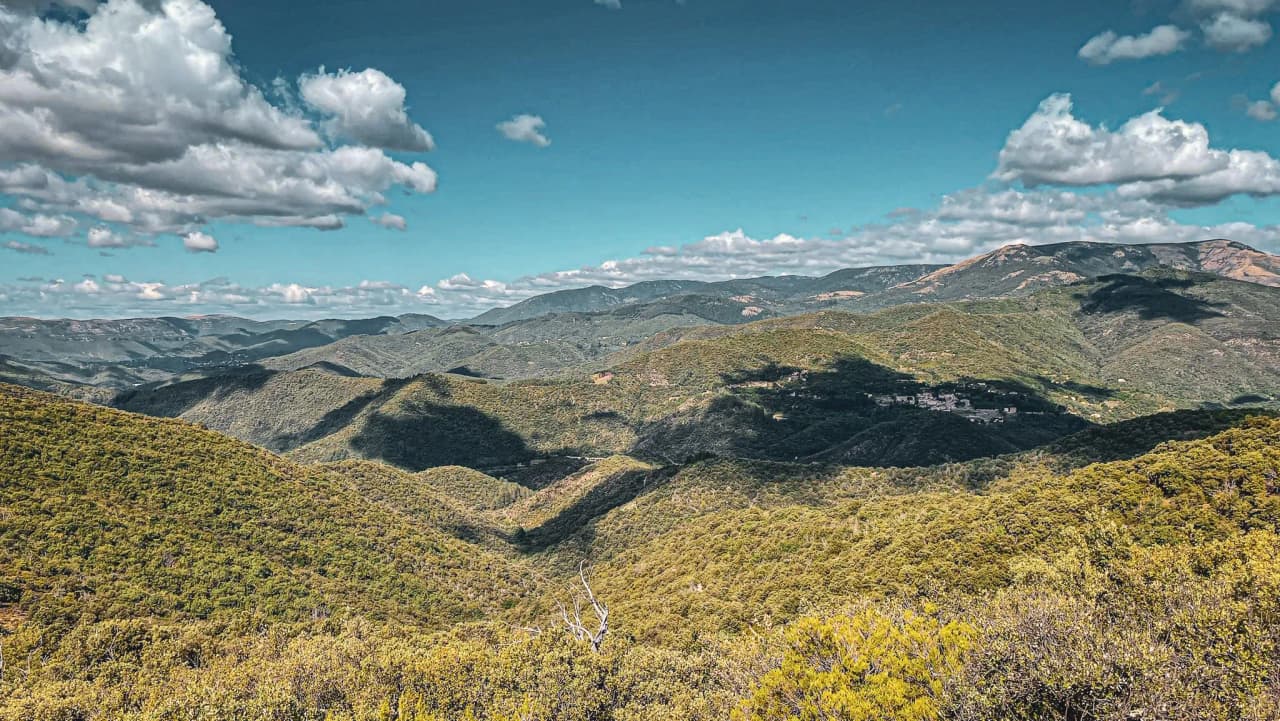 Panoramic views of the Cévennes, lush green valleys and blue skies dotted with clouds, an invitation to get away from it all.
