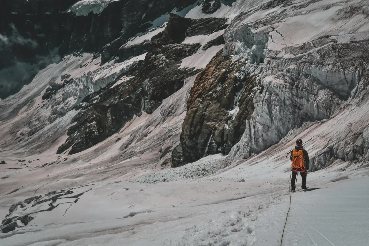 A mountaineer contemplating the majestic glaciers of Mont Rose, ready for adventure.