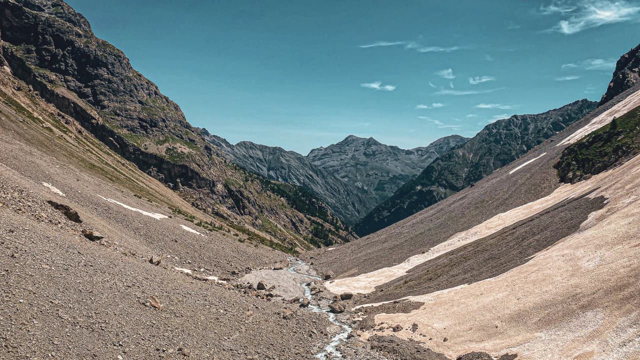 The majestic Écrins valley, with its impressive mountains and winding stream.