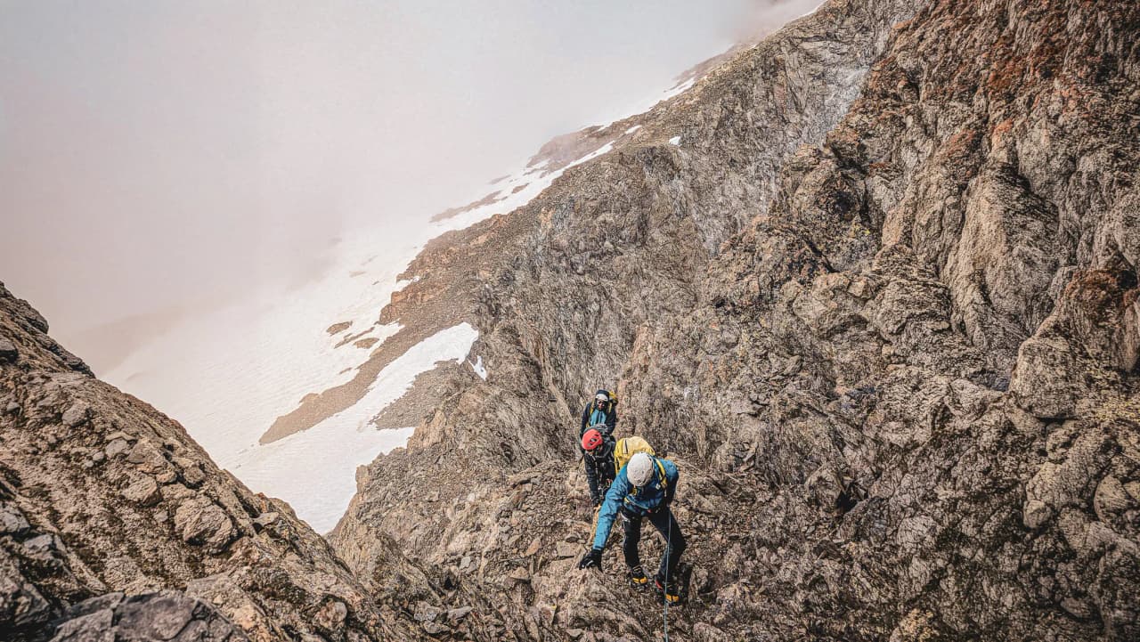 Mountaineers climbing the rocks in the Écrins, majestic peaks to explore.