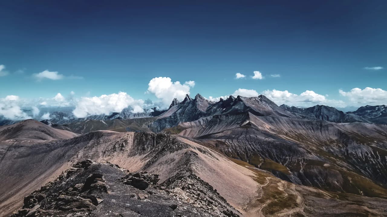 Majestic panorama of the mountains of the Emparis plateau, blue skies and clouds. Adventure in sight!