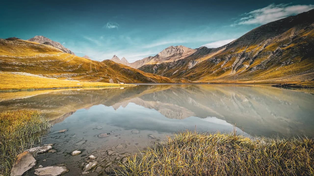 A peaceful lake surrounded by majestic mountains in the heart of the Alps, an enchanting reflection.