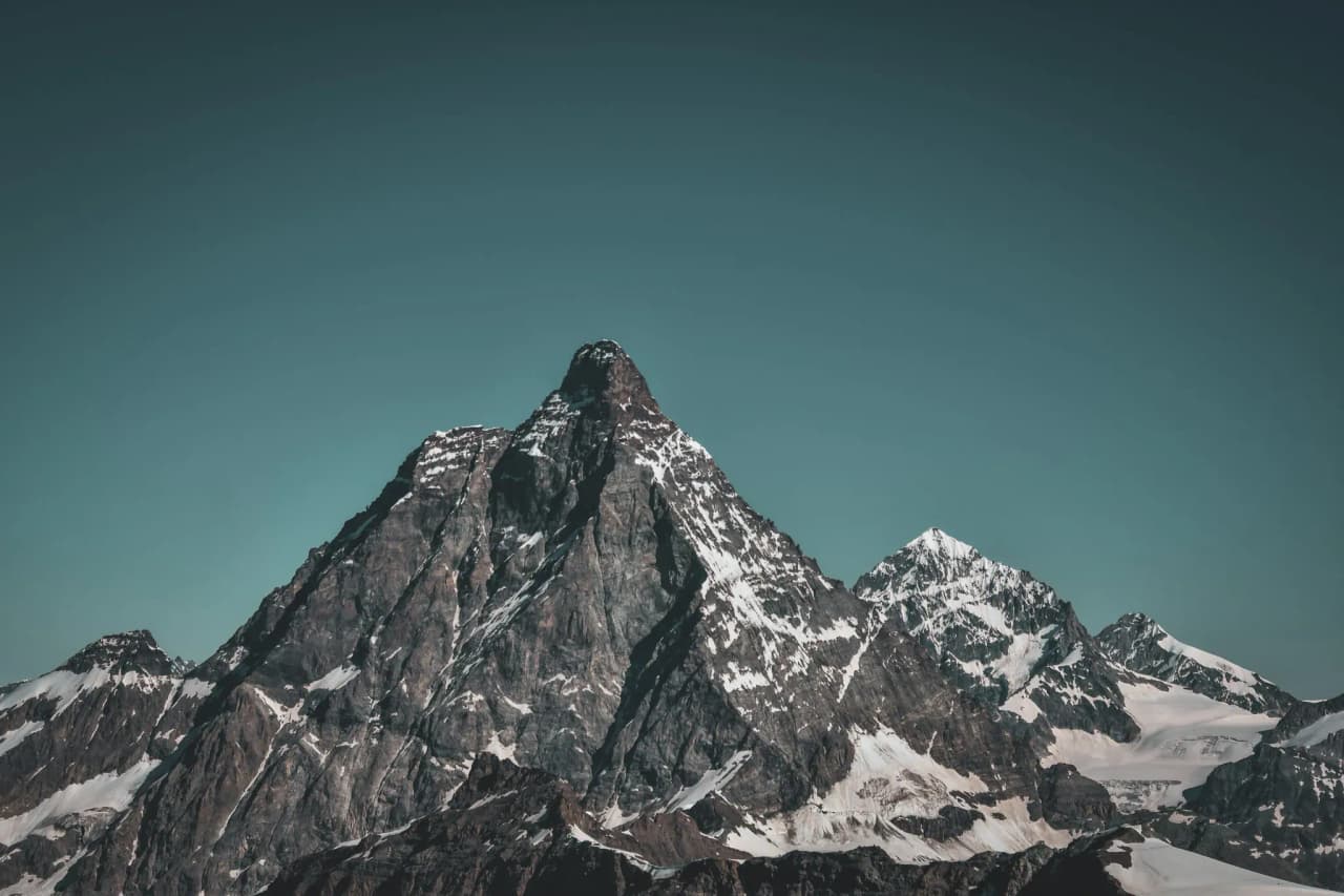 A majestic snow-capped peak with azure skies, an invitation to alpine adventure at Mont Rose.
