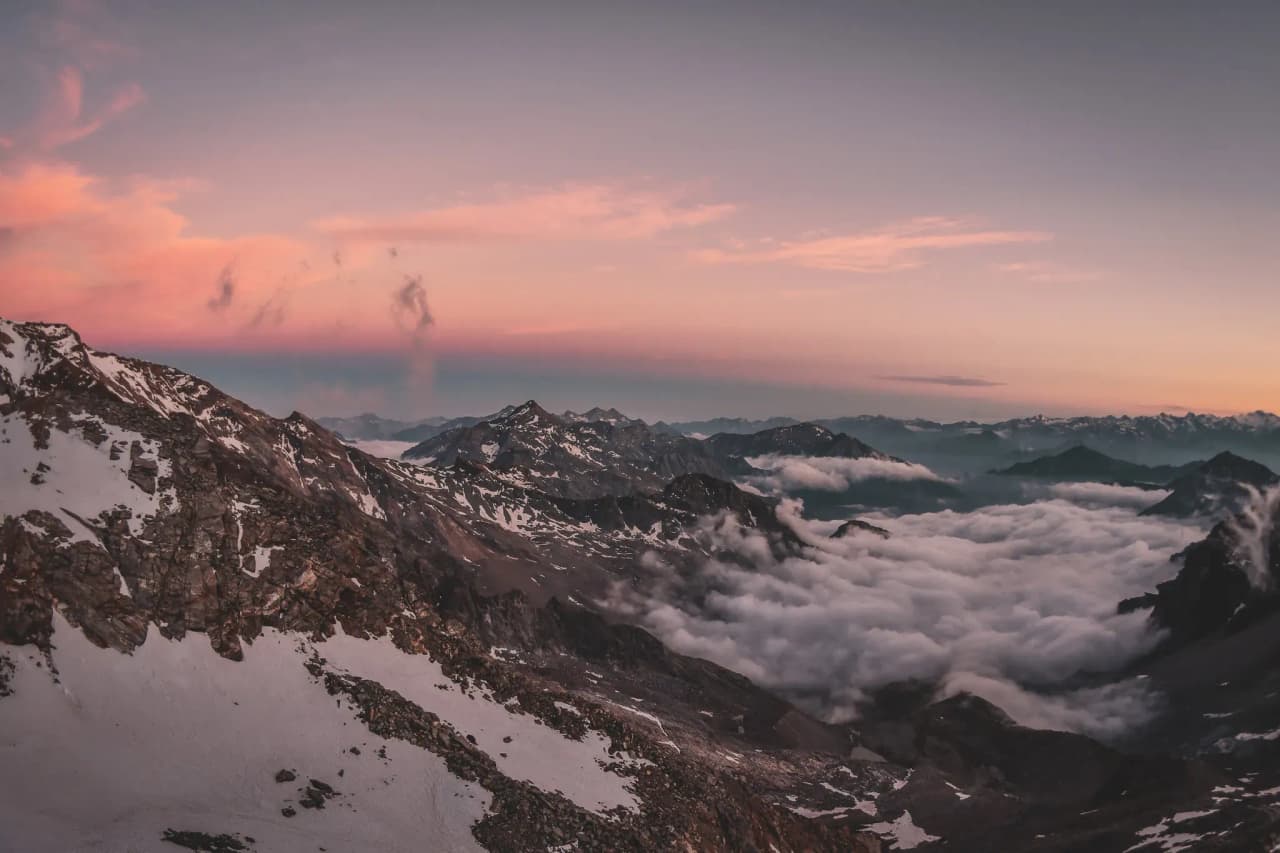 A breathtaking panoramic view of the peaks of Mont Rose, bathed in golden light at sunset.
