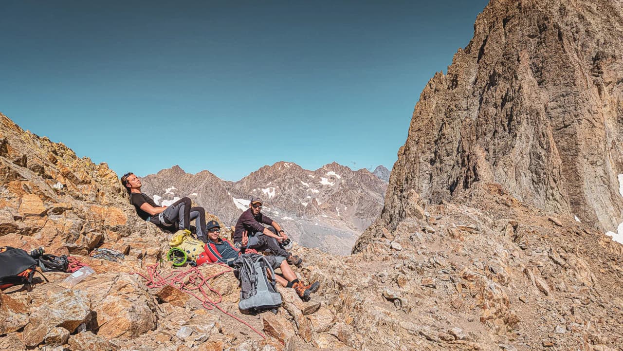 A group of climbers resting on rocks in the mountains, with breathtaking views.