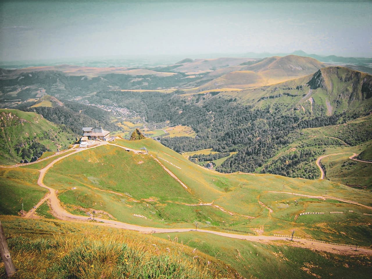 A green panorama of the Massif Central, with volcanic ridges and winding paths. Nature's escape!