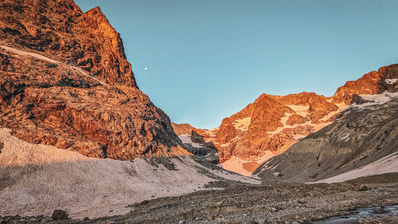 Majestic mountains with golden peaks, blue skies and peaceful glaciers, an invitation to adventure.