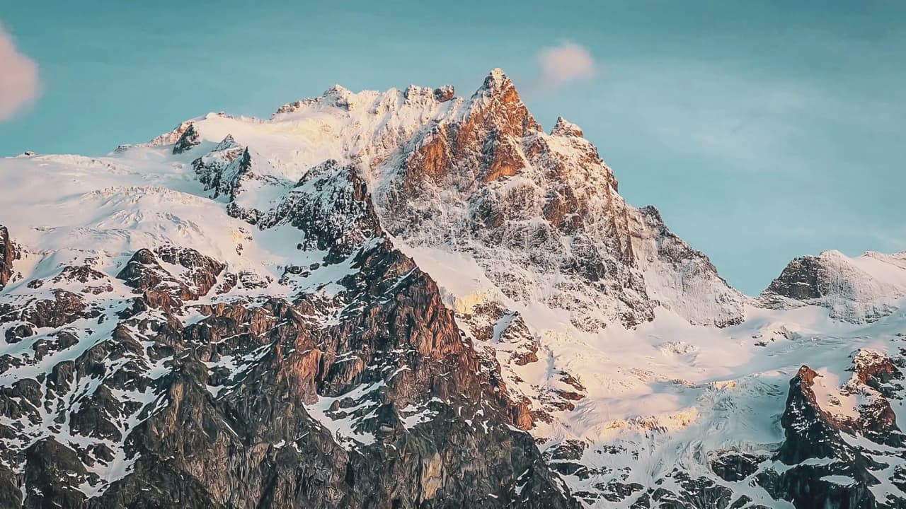 A glimpse of the majestic Aiguilles d'Arves, an Alpine peak under a brilliant sky.