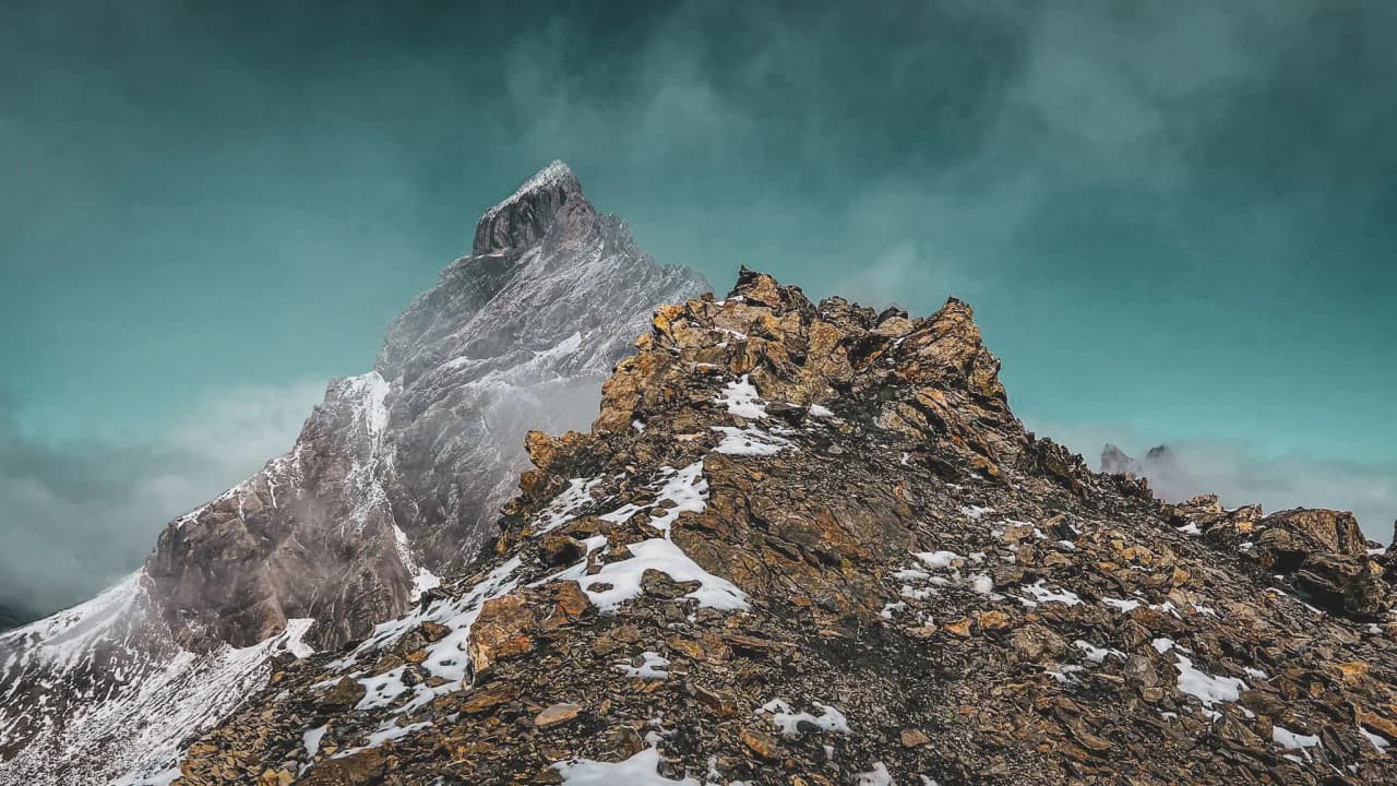 A majestic Alpine landscape of rocky peaks and turquoise skies, inviting you to adventure.