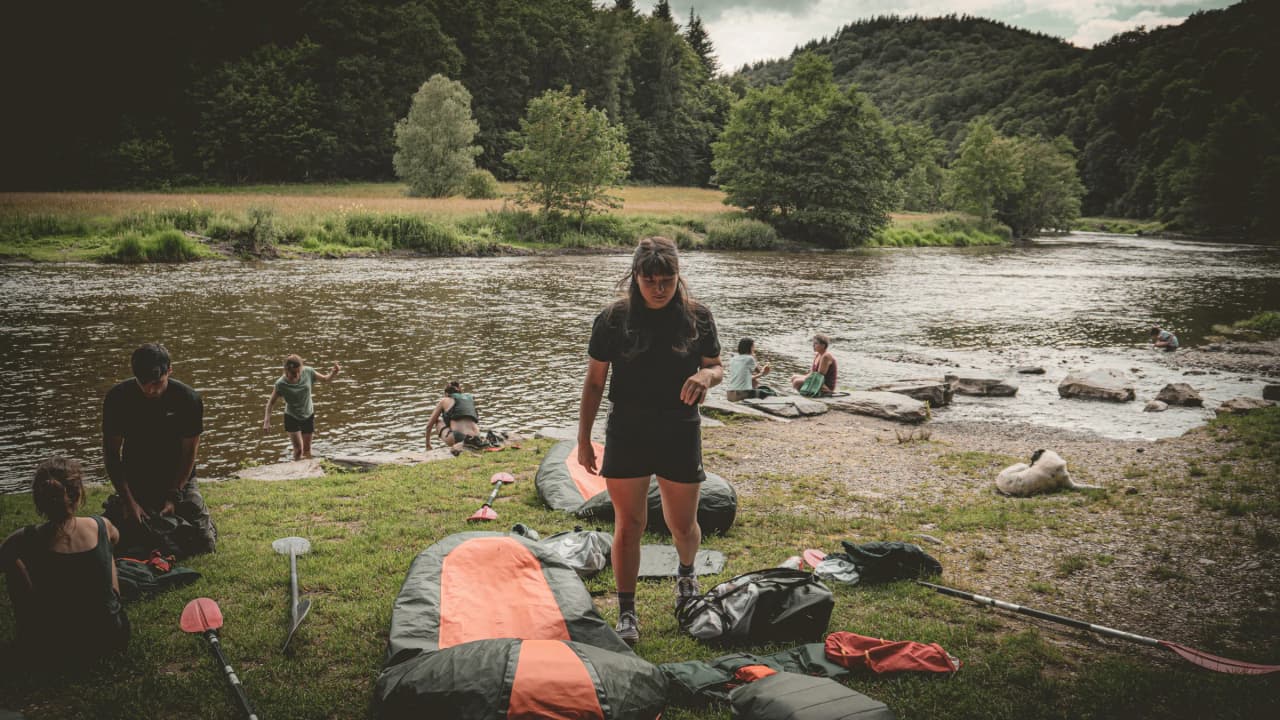 Group ready for a riverside packraft adventure, surrounded by lush green countryside.