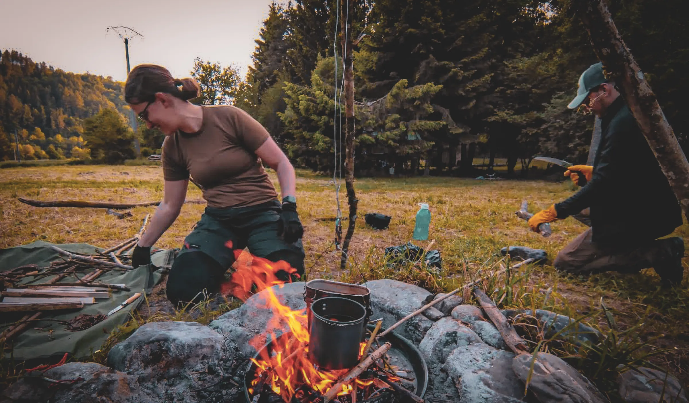 Un feu de camp crépitant, des personnes en pleine activité de survie en forêt, ambiance nature.