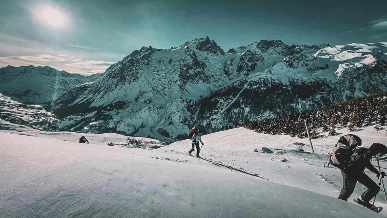 "Snowshoe hikers in a snowy landscape, facing the majestic Cerces mountains".