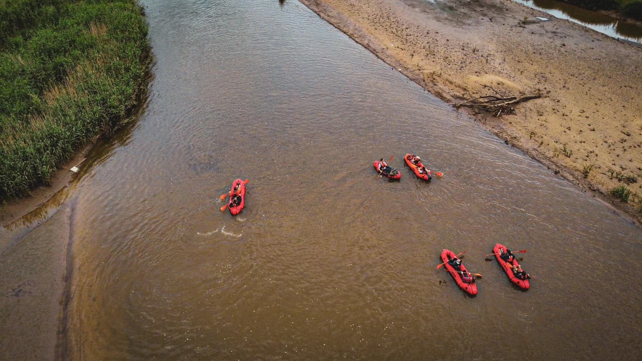 Aperçu d'une expédition en packraft sur une rivière belge, entourée de verdure luxuriante.