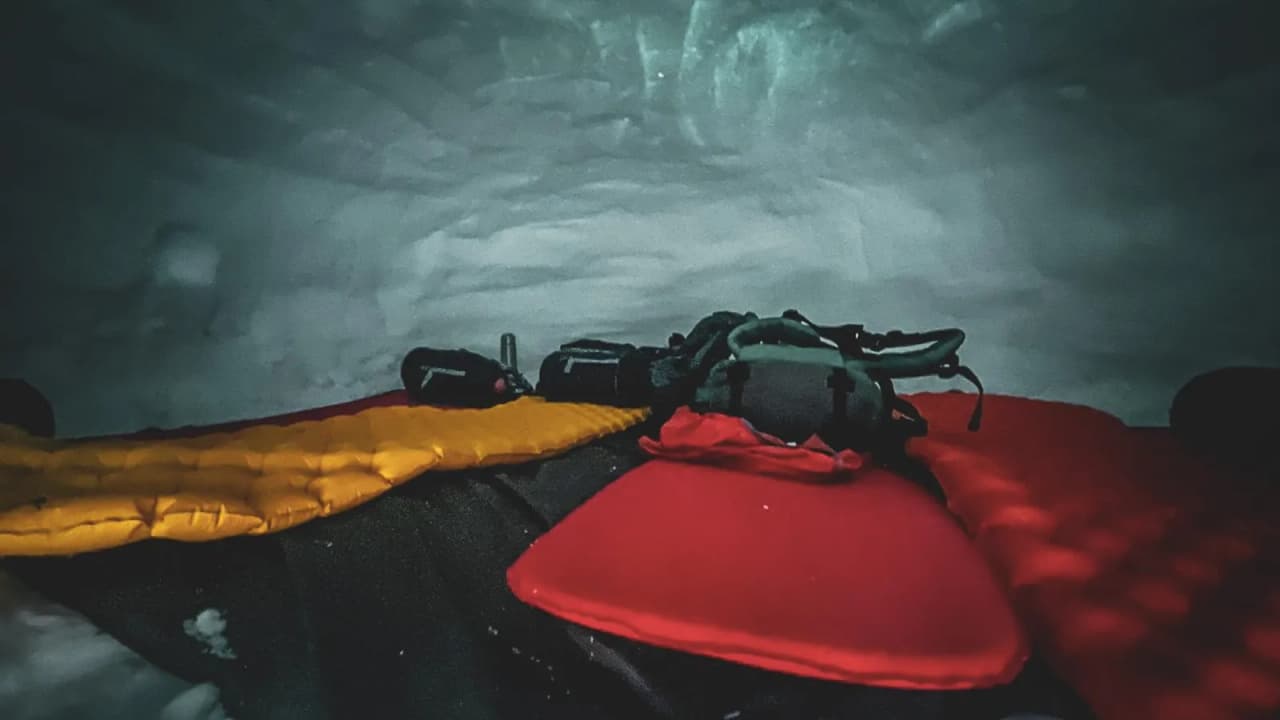 Inside a cosy igloo, with colourful mattresses, ready for a night under the stars in the mountains.