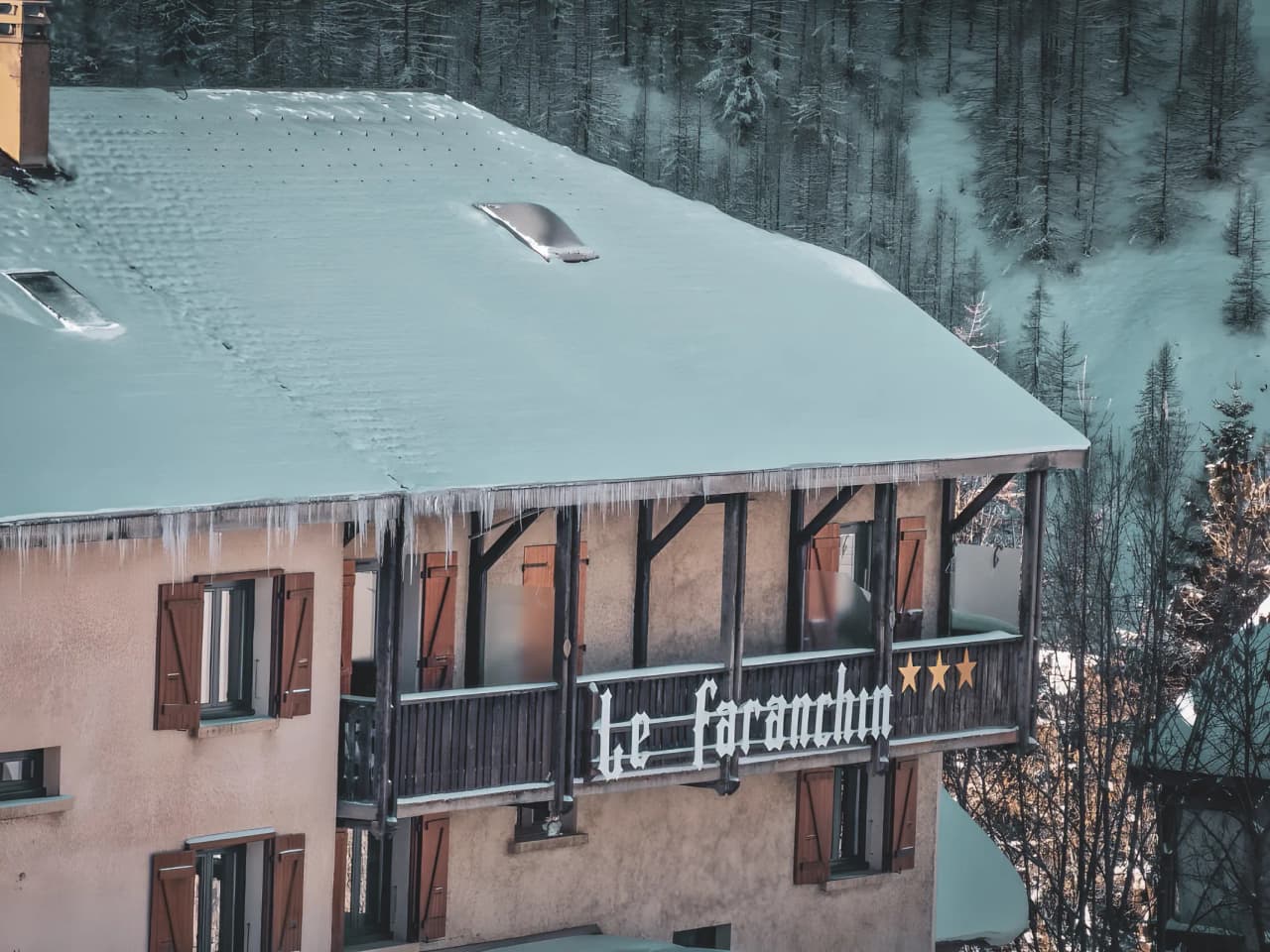 Cosy accommodation under the snow, ideal for a mountain getaway. Glaciers in the background.