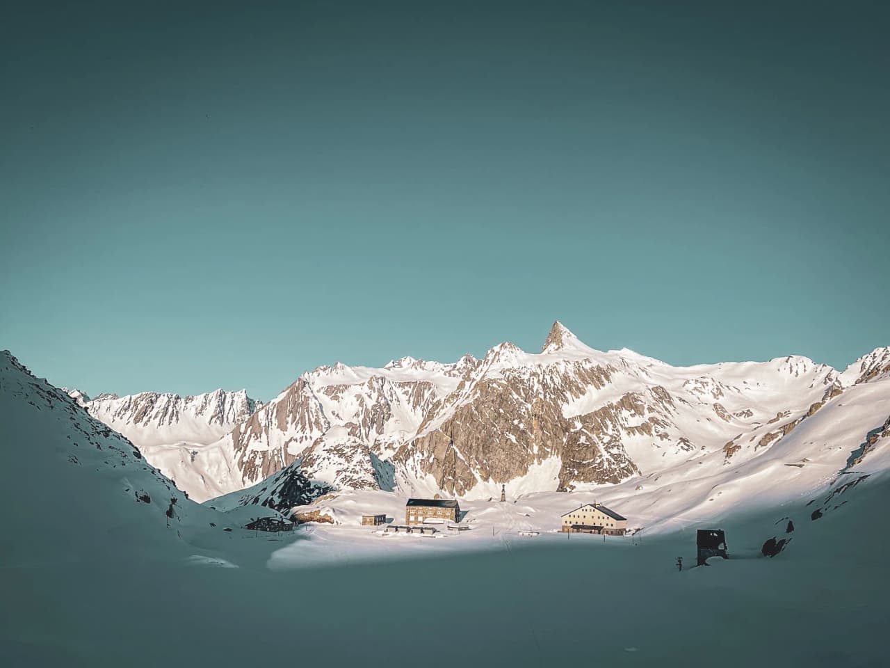 Magnificent Alpine scenery on the Great St Bernard Pass, between snow-capped peaks and cosy mountain huts.