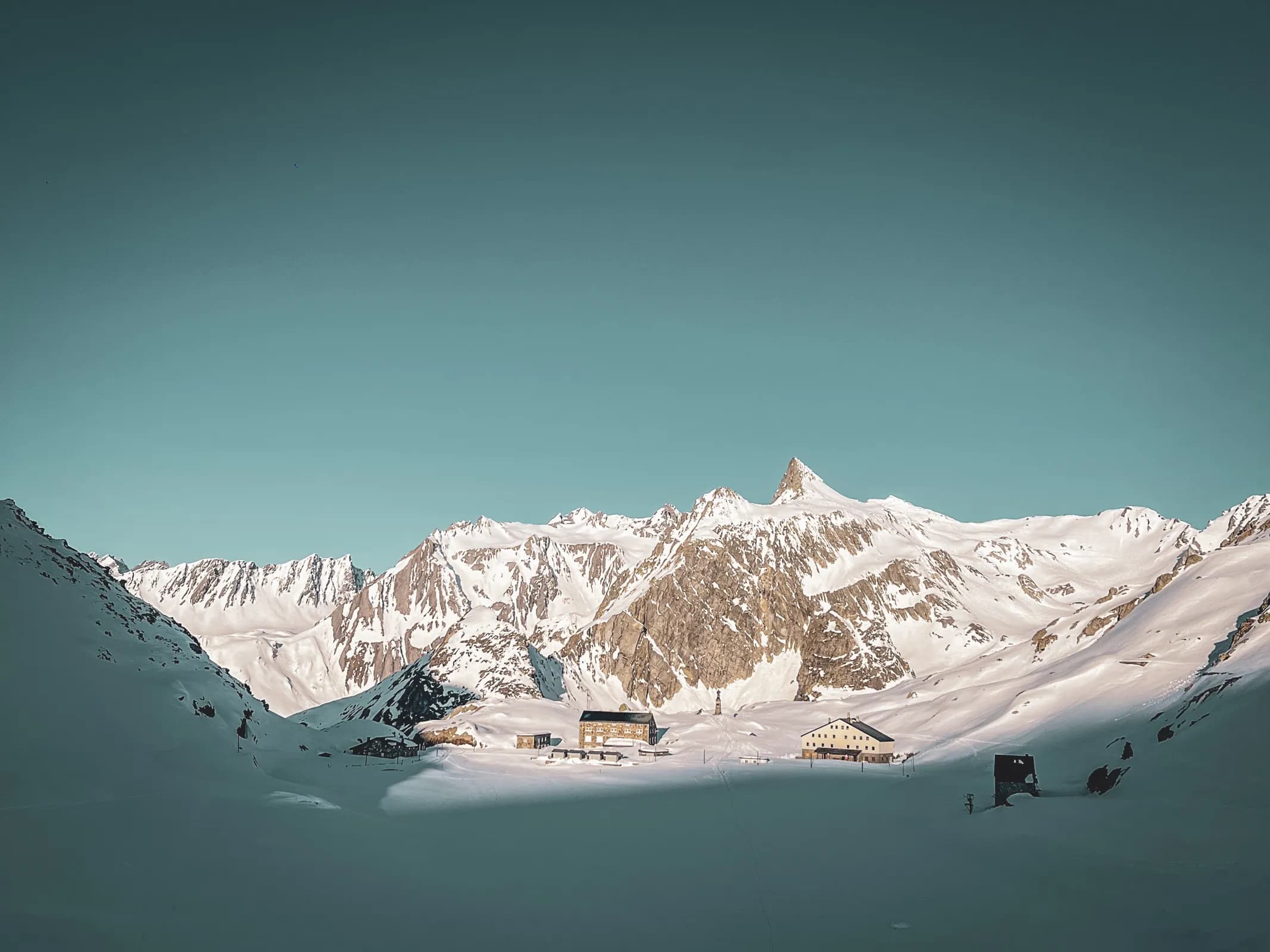 Magnificent Alpine scenery on the Great St Bernard Pass, between snow-capped peaks and cosy mountain huts.