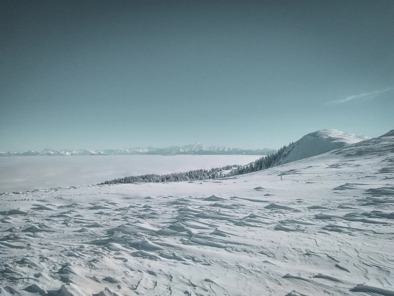 A majestic winter landscape in the Swiss Jura, snow-covered and luminous, an invitation to escape.
