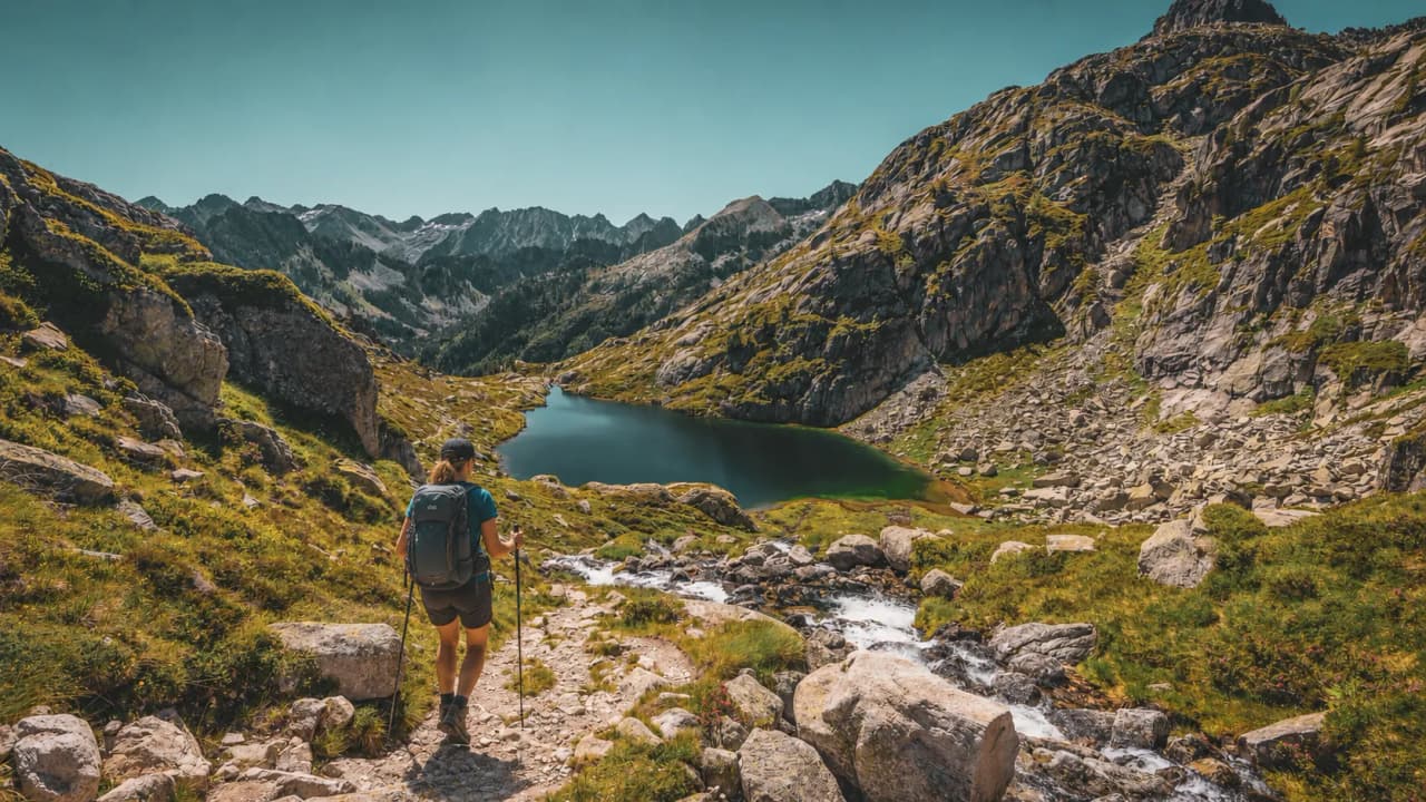 Magnifique paysage des Pyrénées avec un lac d'altitude entouré de montagnes verdoyantes.