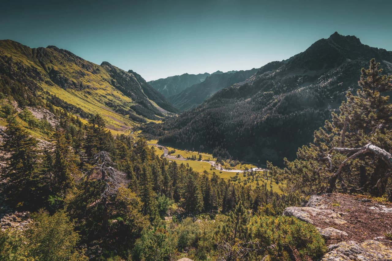 Panorama des Pyrénées, vallées verdoyantes, sommets majestueux et nature préservée invitant à l'aventure.