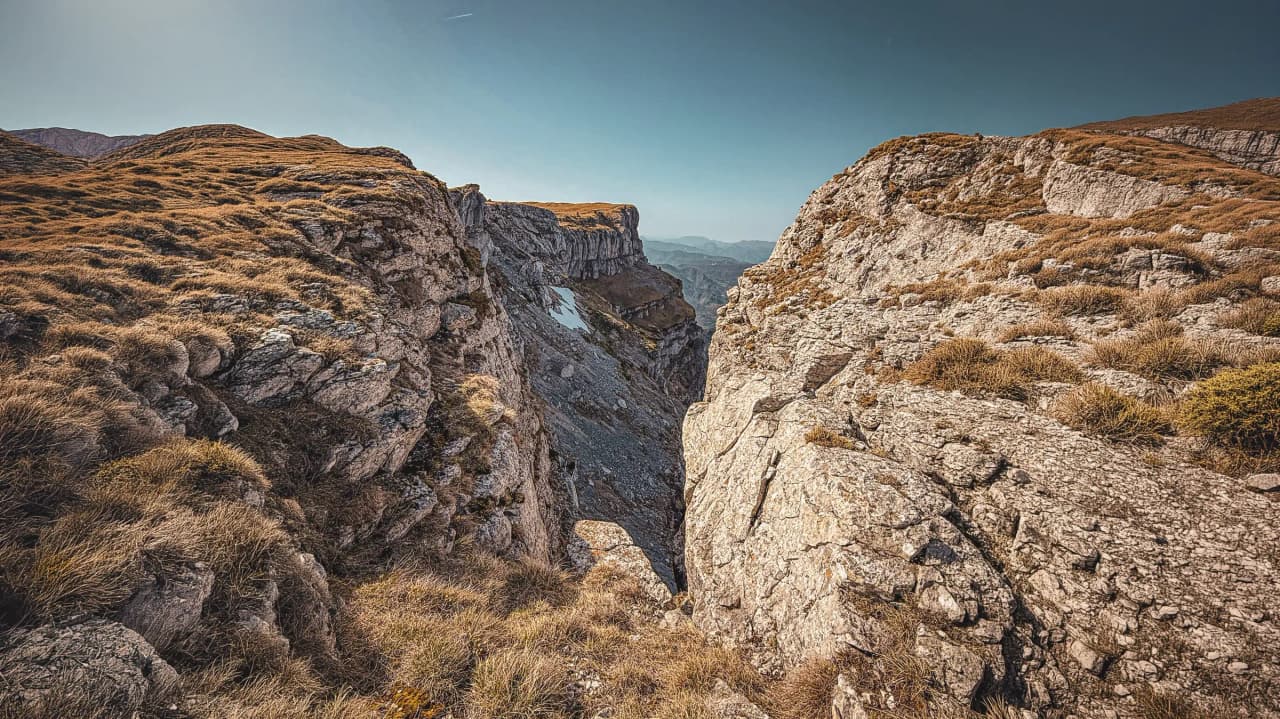 Un paysage majestueux du Vercors avec des falaises rocheuses et des prairies dorées.