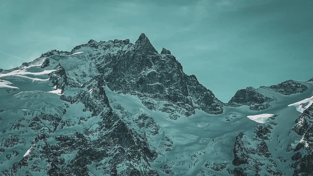 Majestic snow-capped mountains under a turquoise sky, an invitation to adventure in the heart of nature.