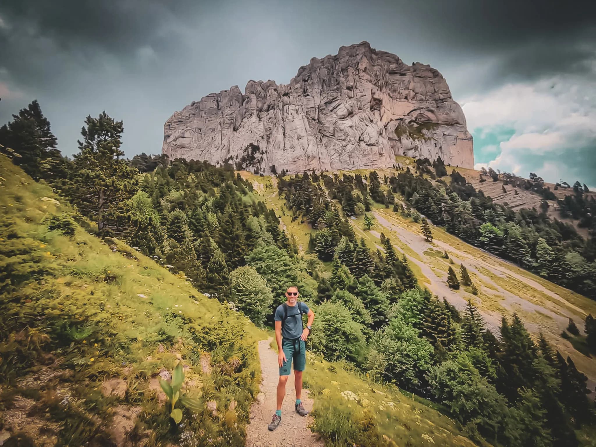 Hikers on a green trail, with majestic Mont Aiguille in the background. Nature and adventure!