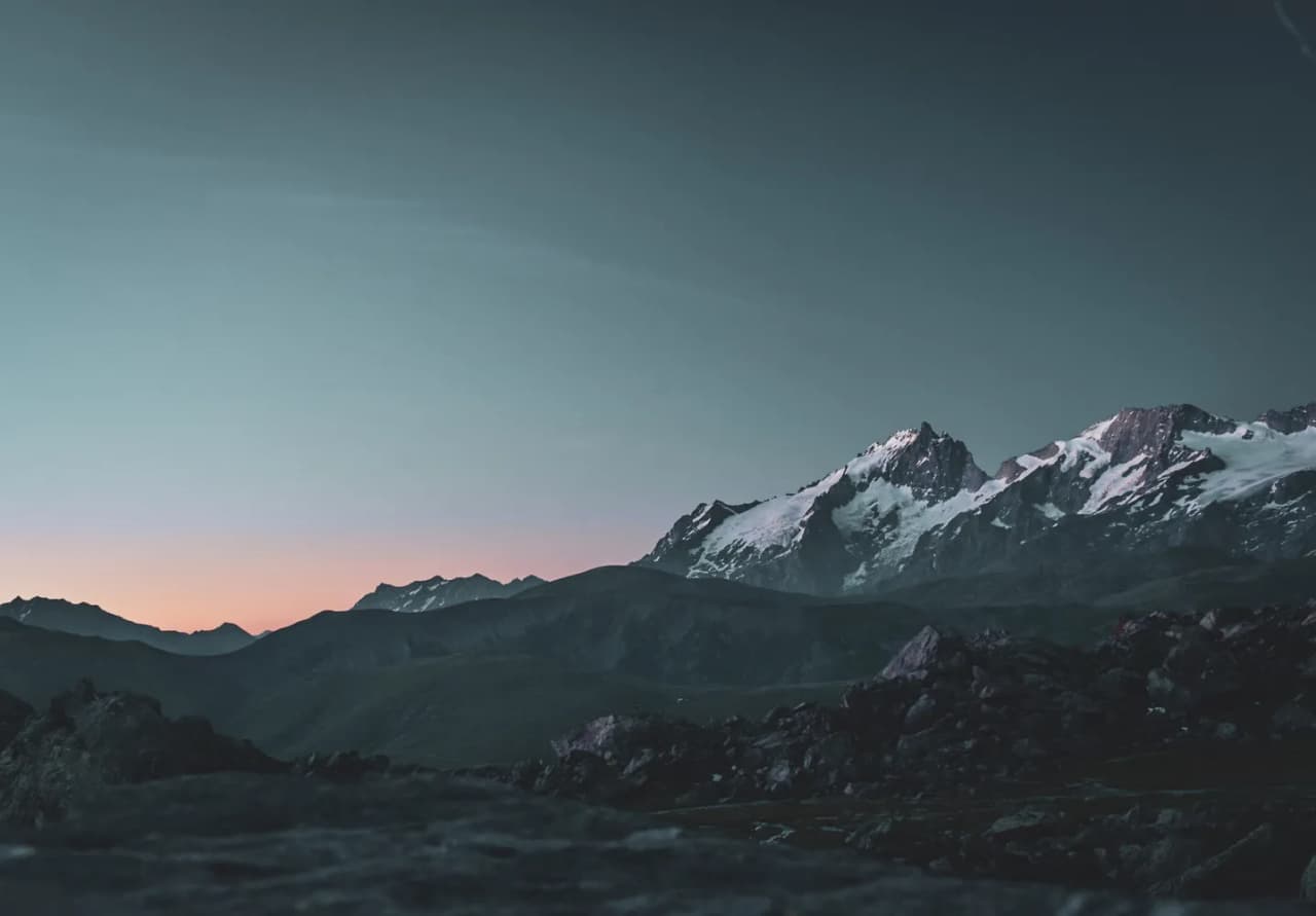 Sunset over snow-capped mountains, an invitation to winter adventure.