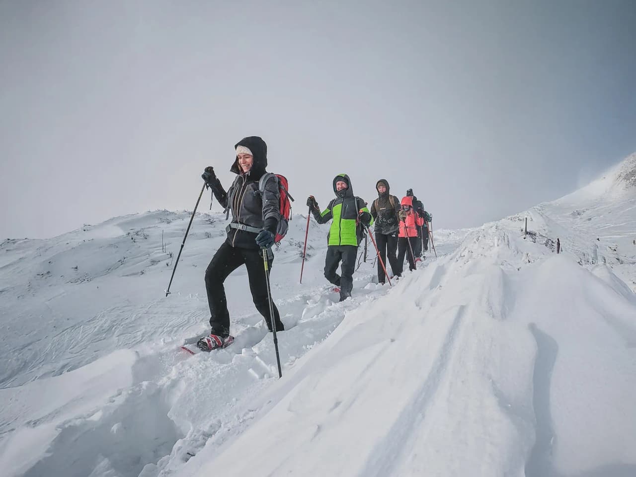 A group of snowshoe hikers happily making their way through the snow in the Vosges.