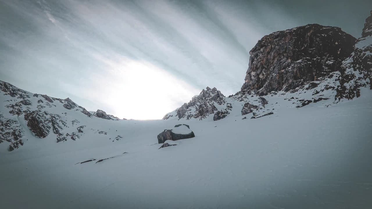 Vast snow-covered Alpine landscapes, majestic mountains under dramatic skies, an invitation to adventure.