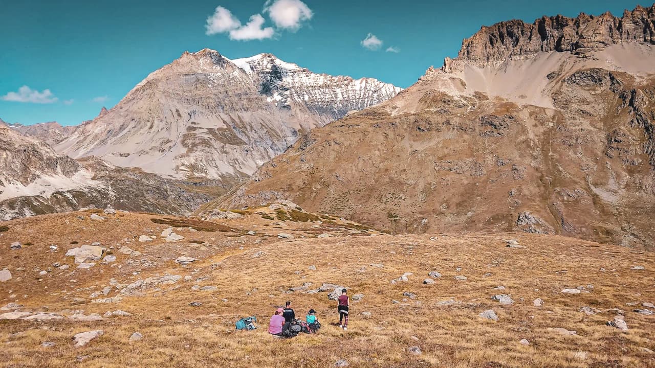 Randonneurs admirant les sommets majestueux du Parc National de la Vanoise, sous un ciel bleu.