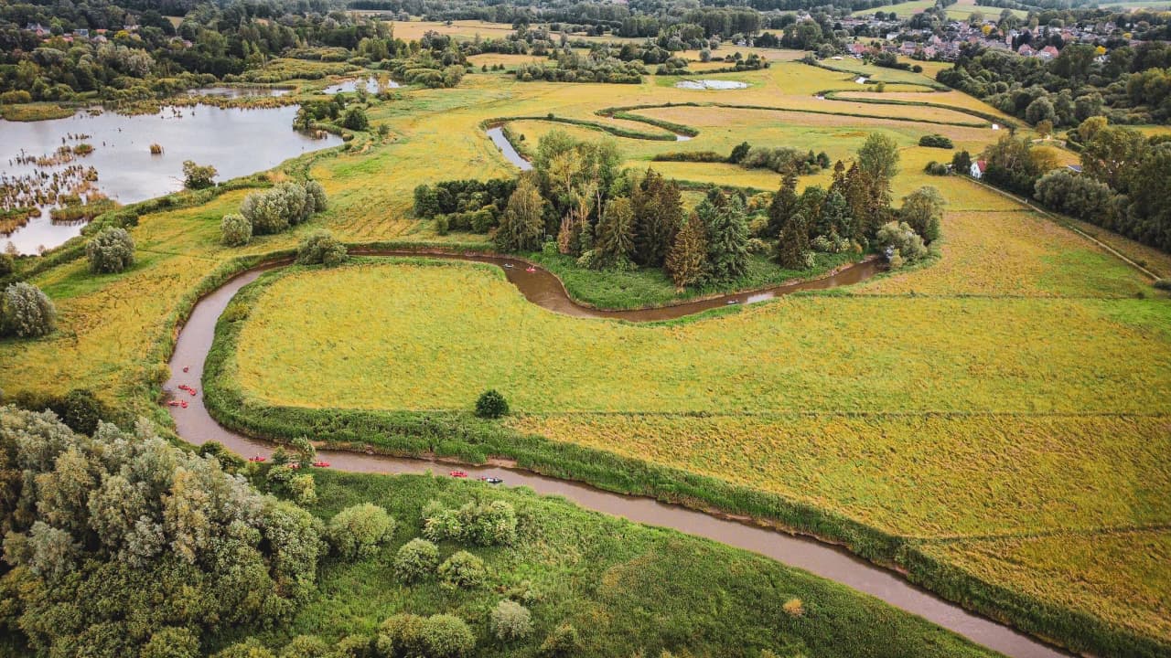 Un paysage verdoyant, serpents de rivières et kayaks, parfait pour une aventure en pleine nature.