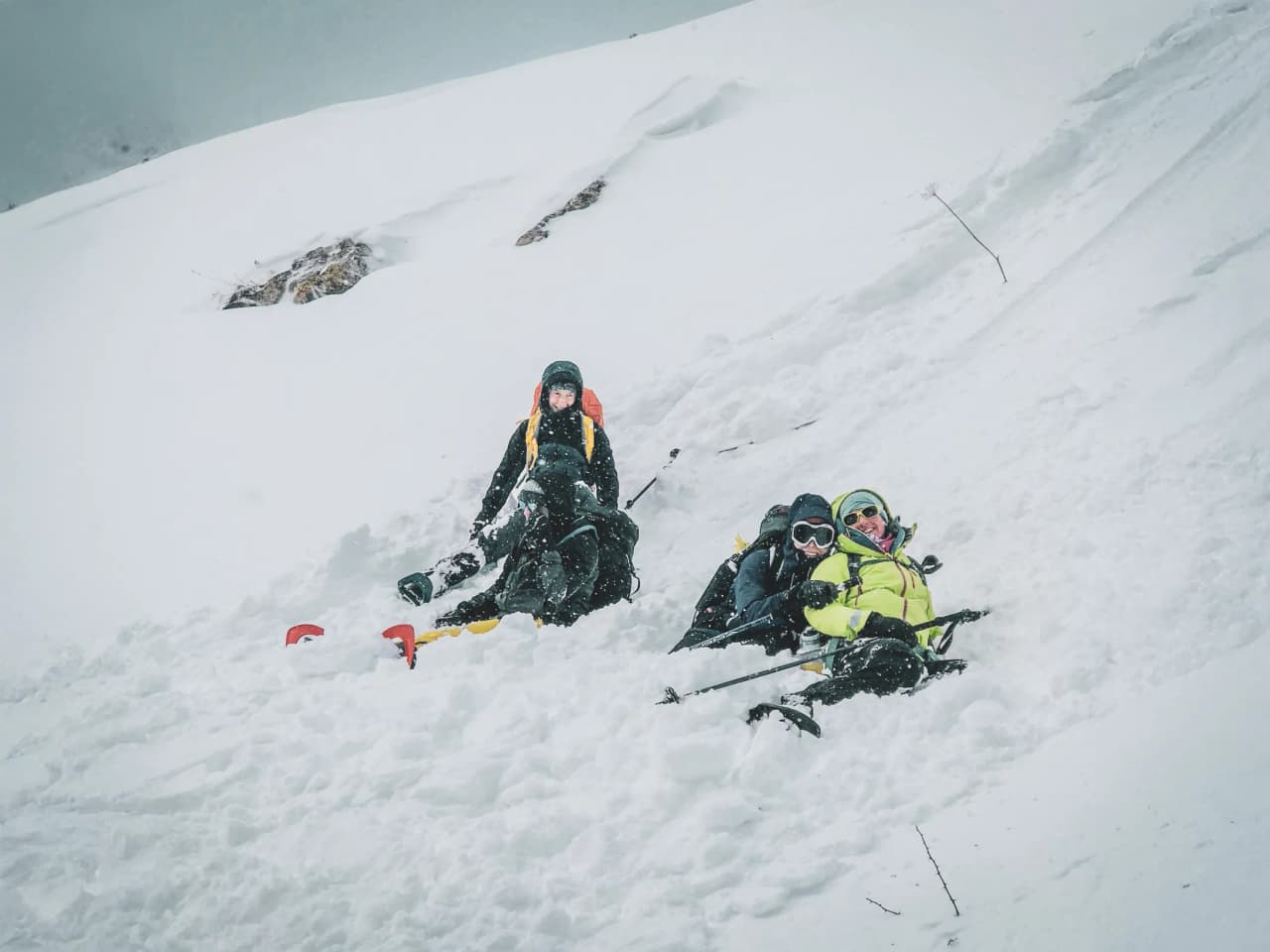 Three snowshoe trekkers enjoying themselves in the snow in front of the majestic glaciers of the Écrins.