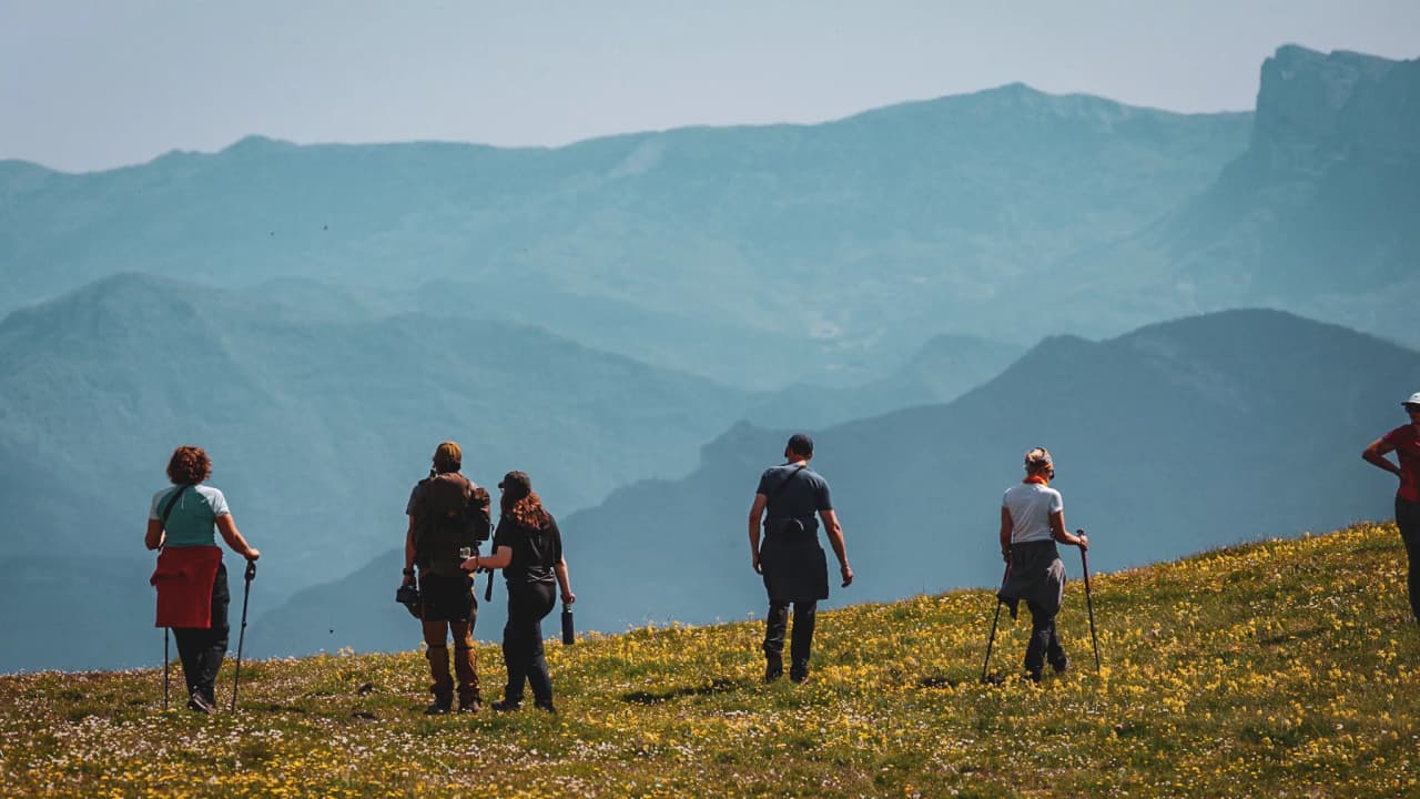 Groupe de randonneurs sur un sommet du Vercors, face à un paysage spectaculaire au coucher de soleil.