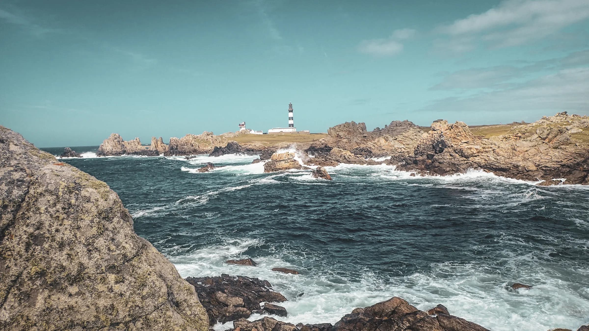 Escape to the Molène archipelago, with crashing waves near a majestic lighthouse.