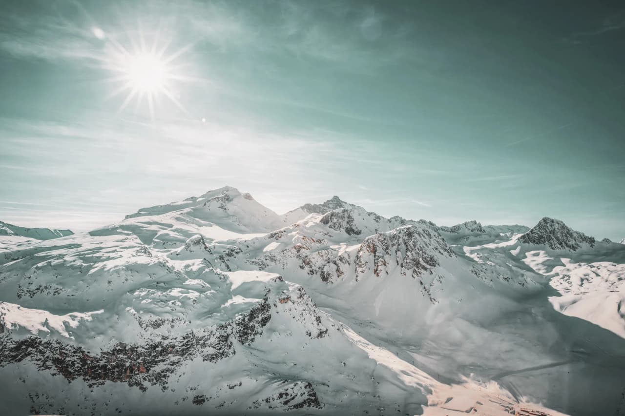 Snow-covered mountain scenery in bright sunshine, inviting you to embark on a snowshoeing adventure.