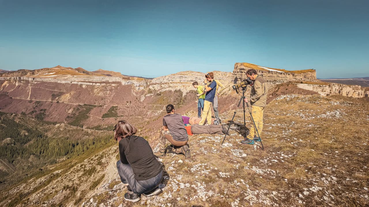 Groupe de randonneurs observant un paysage époustouflant dans le Vercors, sous un ciel clair.