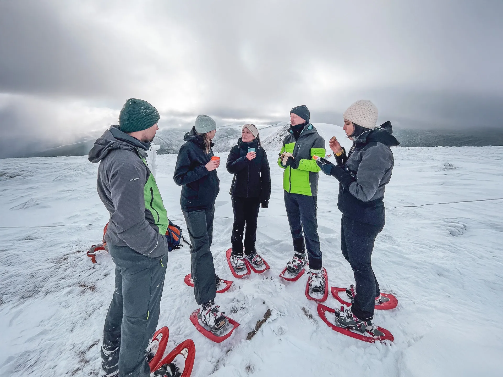 A group on snowshoes in the snow, sharing a friendly moment in the heart of the Vosges.