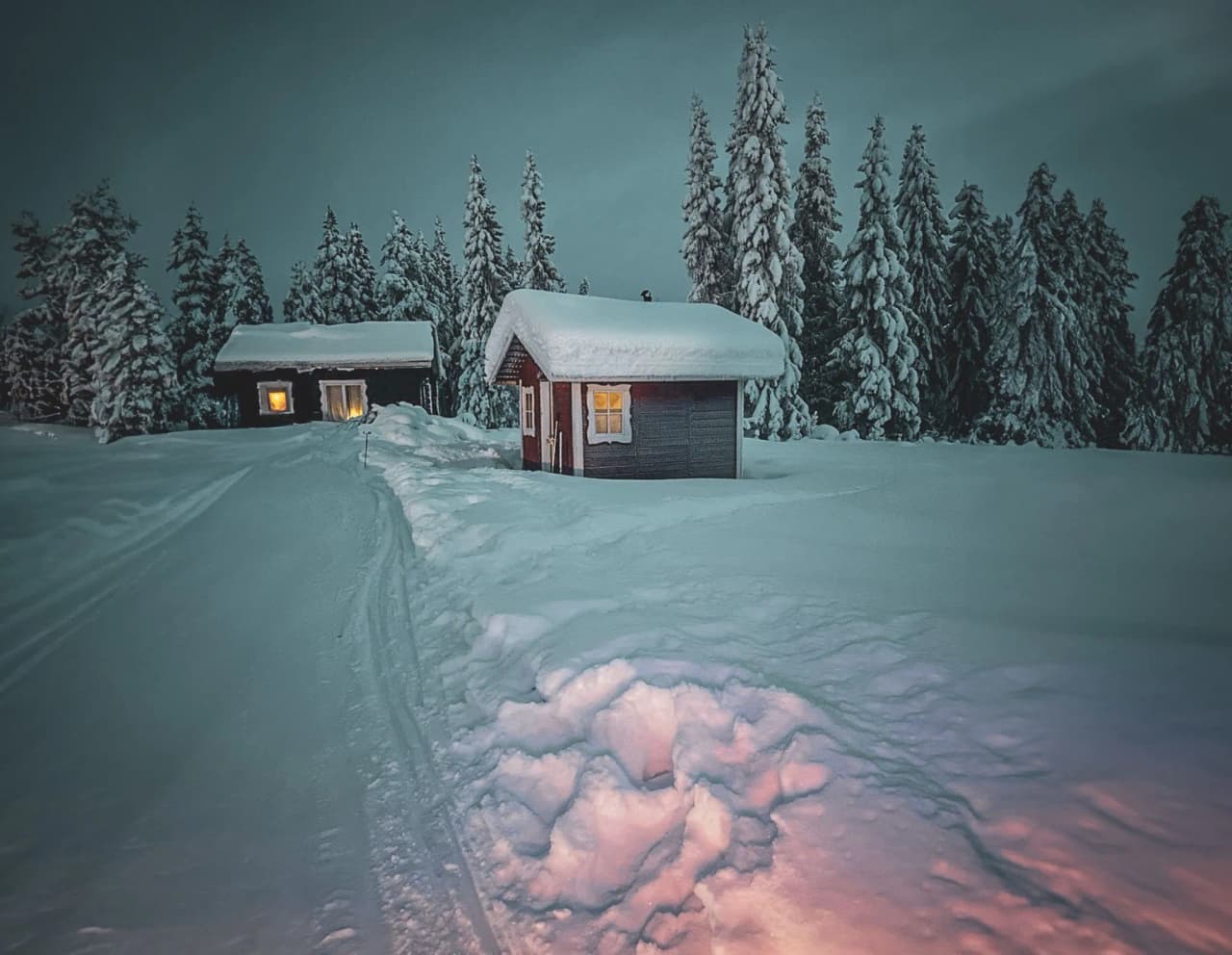 Snow-covered cabins under a night sky in Lapland, an invitation to a magical winter adventure.