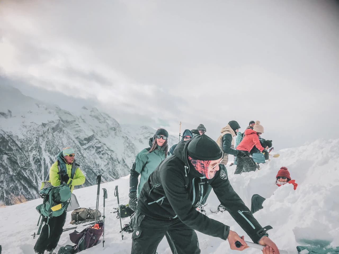 A group of adventurers on snowshoes, exploring a snow-covered landscape facing majestic glaciers.