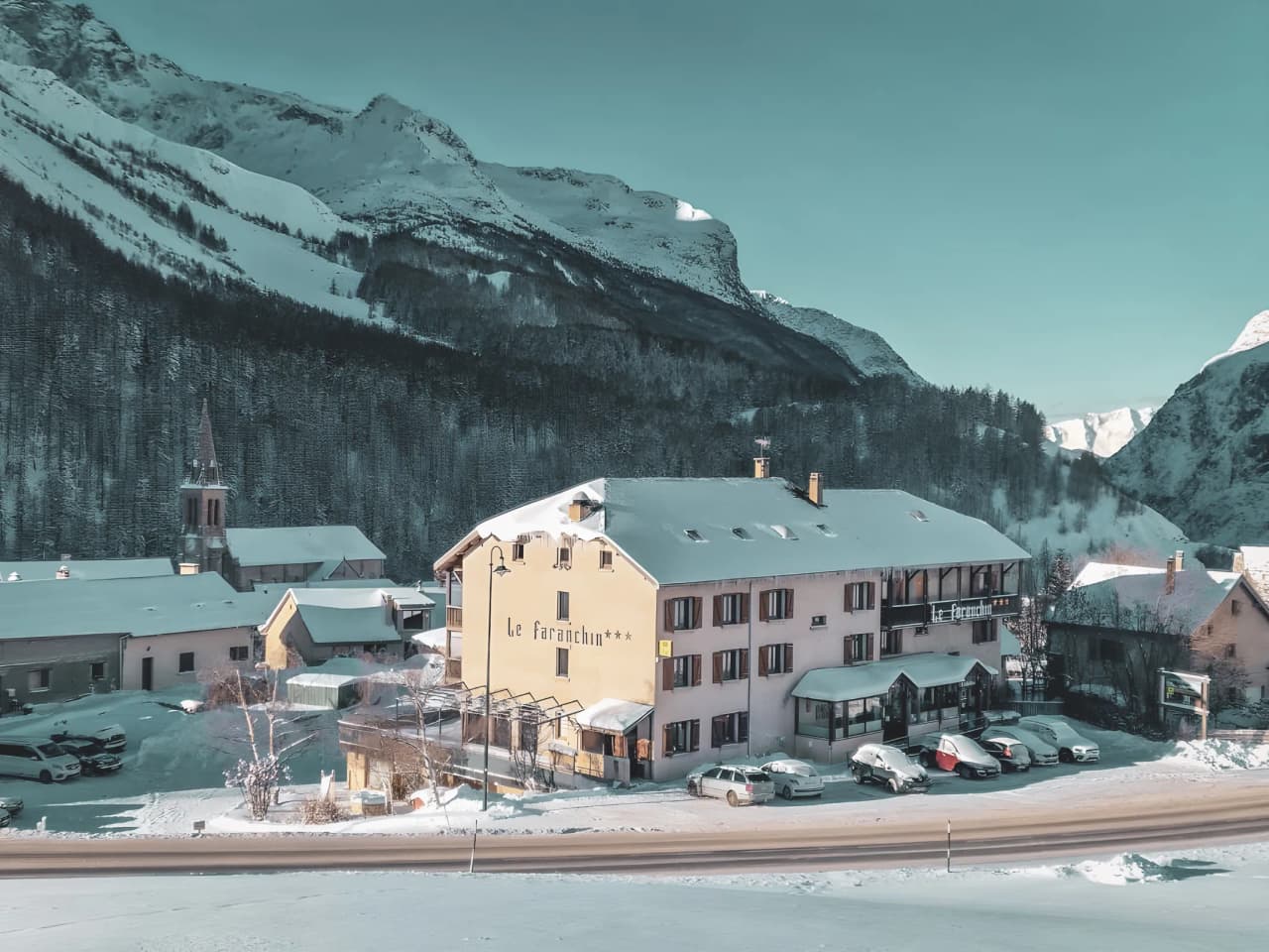 A charming alpine mountain hut in the snow, surrounded by majestic mountains, inviting you to embark on an adventure.