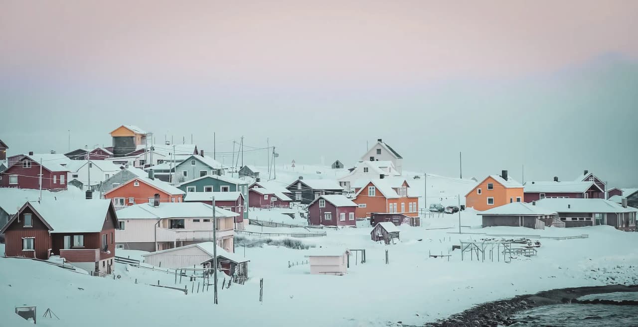 Charming, colourful chalets in Norwegian Lapland, surrounded by immaculate snow and pastel skies.