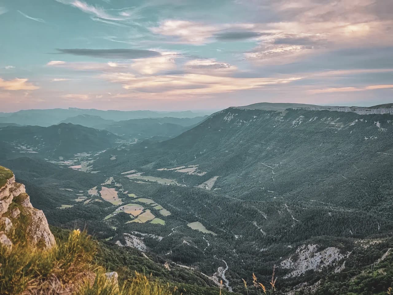 Les montagnes du Vercors, paysages verdoyants et ciel pastel au crépuscule.