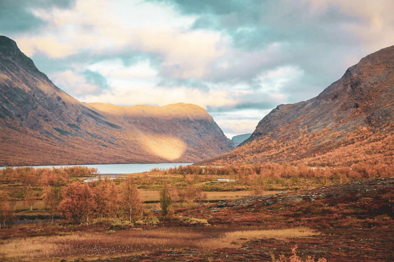 Paysage automnal en Laponie suédoise, vallées majestueuses et lacs scintillants invitant à l’aventure.